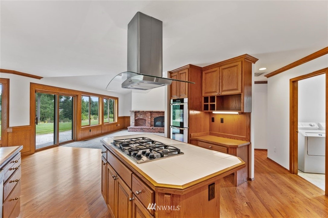 4801 166th Place Southeast Bothell, WA 98012 - Photo 10 of 40 a kitchen with stainless steel appliances a stove a sink dishwasher and white cabinets with wooden floor