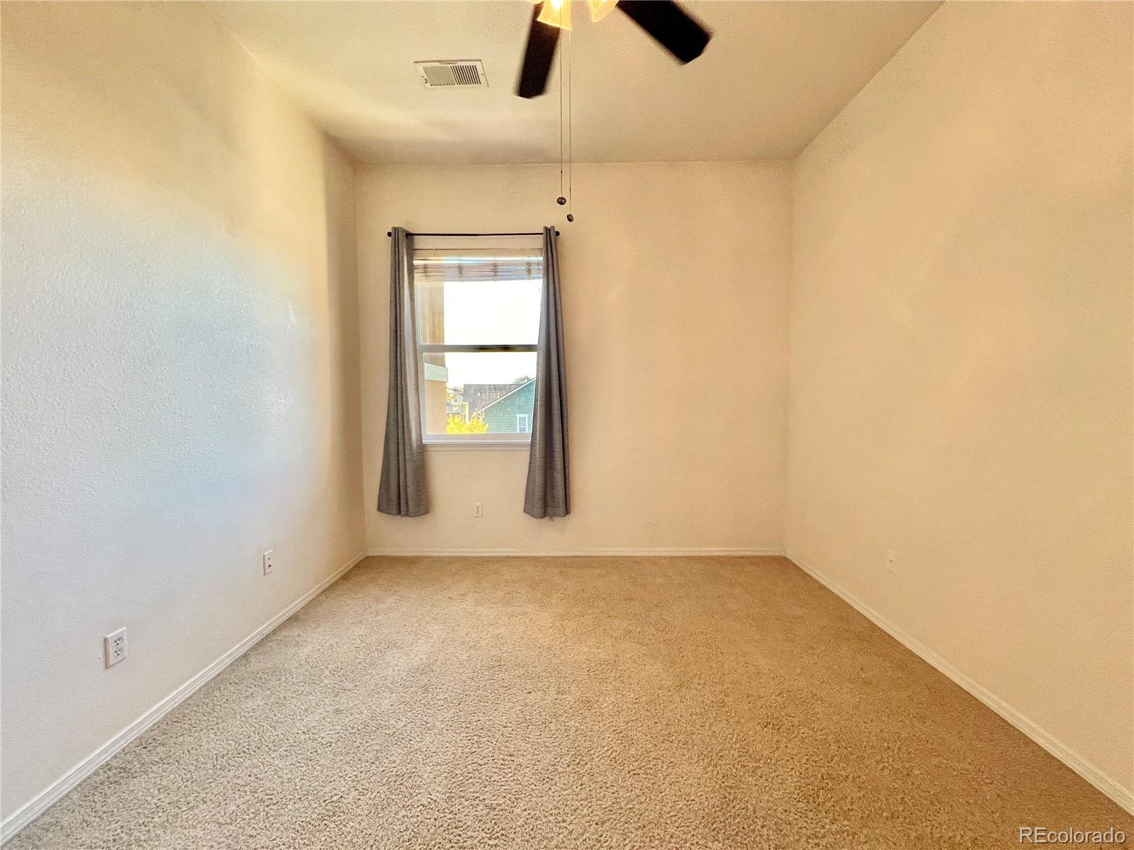 8467 Canyon Rim Circle, Unit 303 Parker, CO 80134 - Photo 11 of 17 an empty room with ceiling fan and window