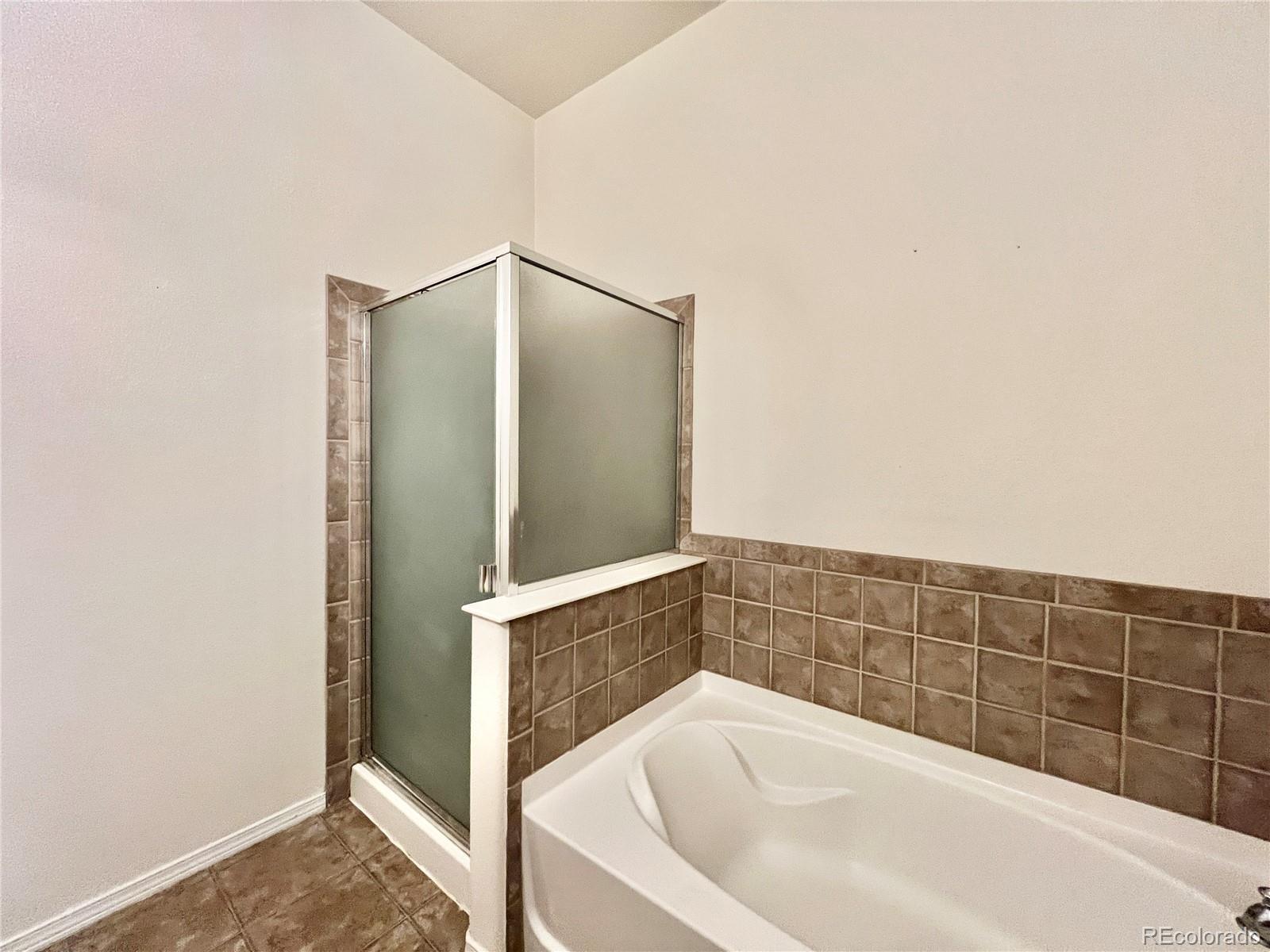 8467 Canyon Rim Circle, Unit 303 Parker, CO 80134 - Photo 15 of 17 a bathroom with a bathtub and a shower