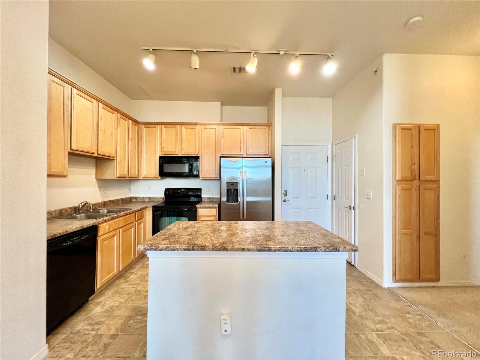 8467 Canyon Rim Circle, Unit 303 Parker, CO 80134 - Photo 3 of 17 a kitchen with stainless steel appliances granite countertop a refrigerator a stove top oven and sink