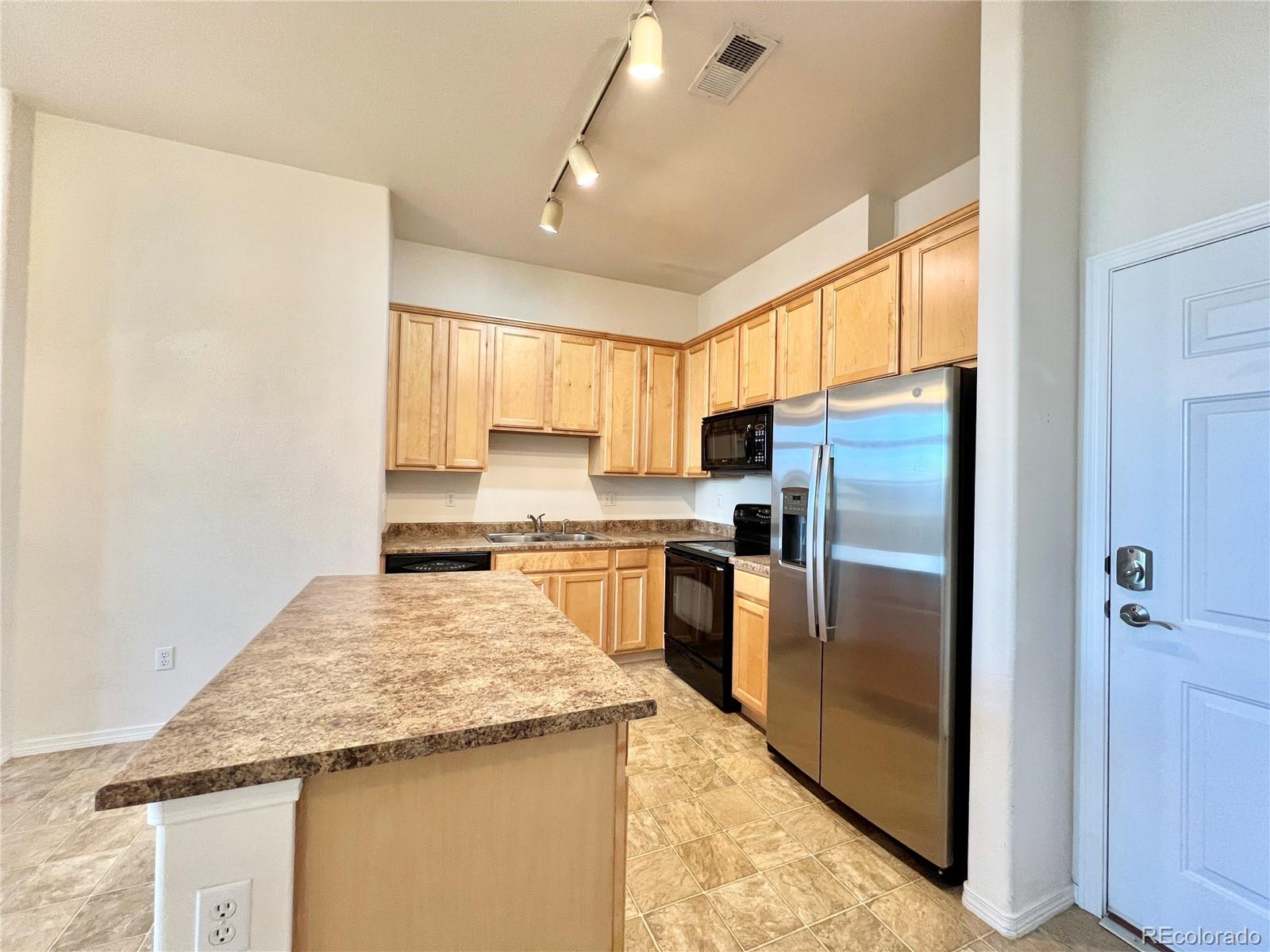 8467 Canyon Rim Circle, Unit 303 Parker, CO 80134 - Photo 4 of 17 a kitchen with granite countertop a refrigerator and a stove