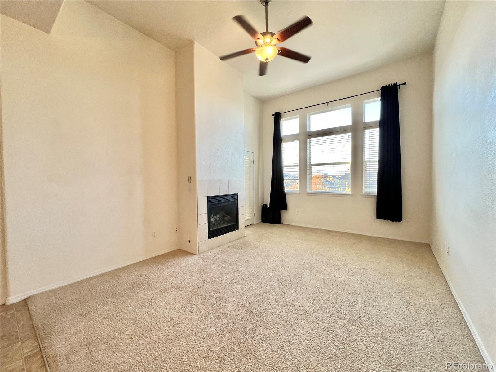8467 Canyon Rim Circle, Unit 303 Parker, CO 80134 - Photo 10 of 17 an empty room with windows and ceiling fan