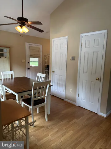 a livingroom with dining area a chandelier a wooden table and chairs