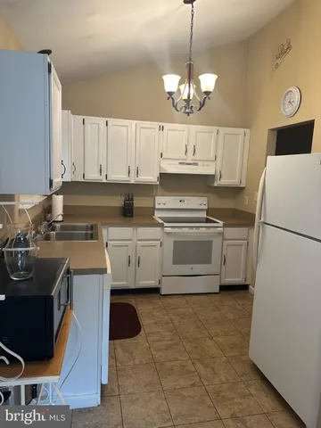 a kitchen with a sink a stove and cabinets