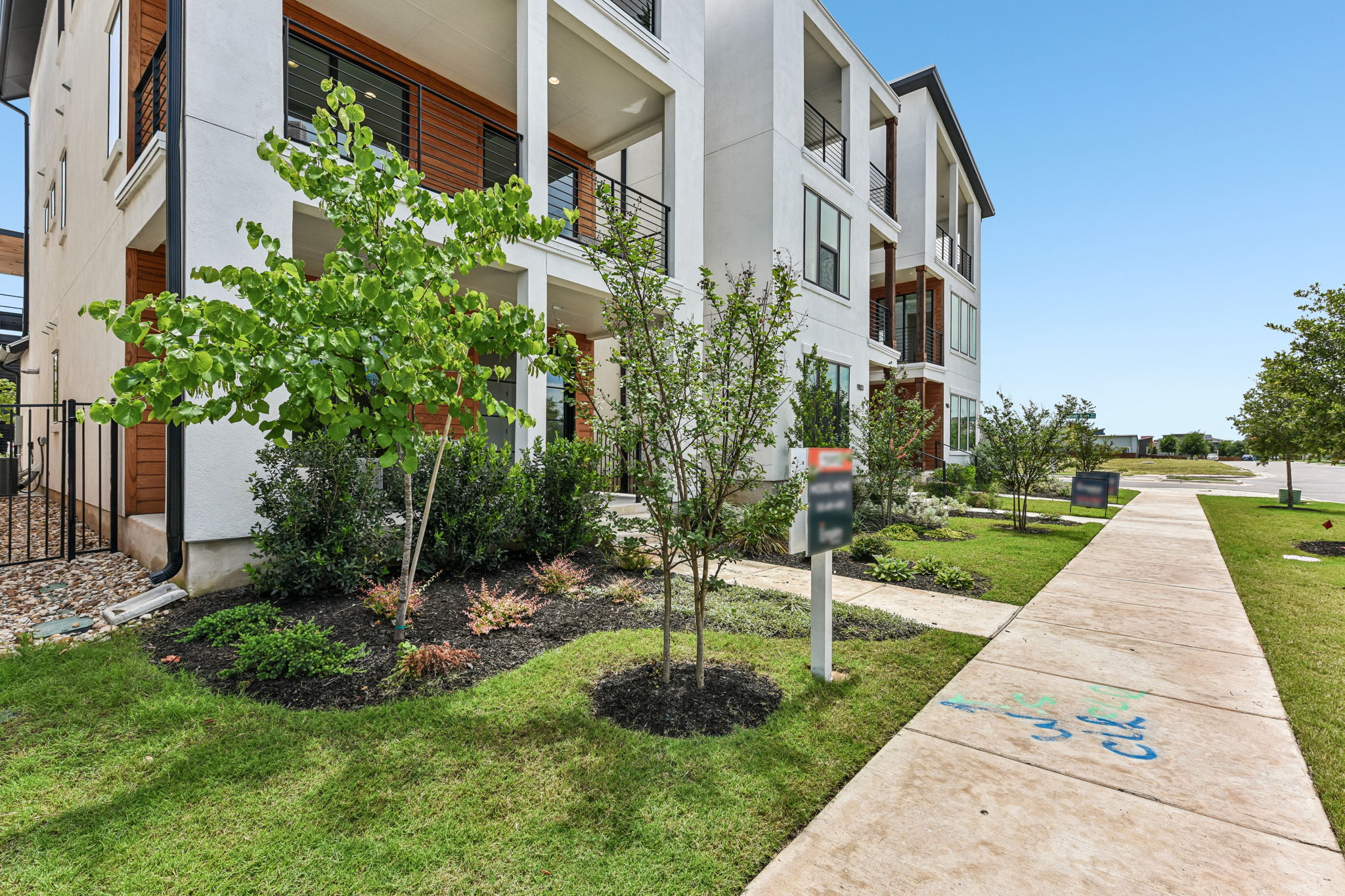 9101 Cattle Baron Path Austin, TX 78747 - Photo 6 of 40 Modern architecture meets vibrant landscaping in this contemporary townhome community.