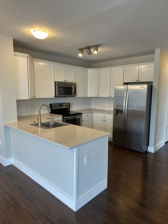 a kitchen with granite countertop a refrigerator and a stove top oven