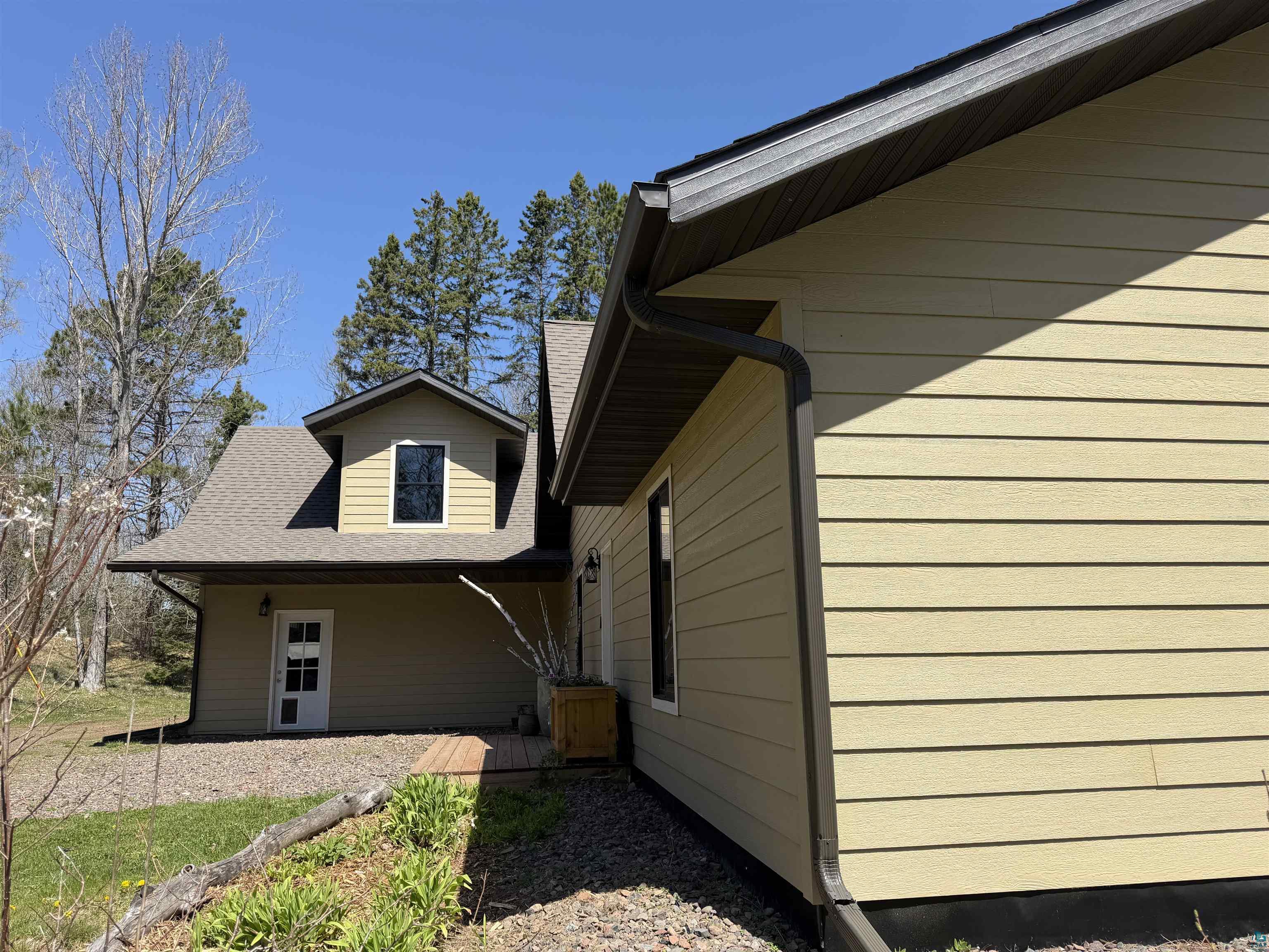 5274 Marble Lake Road Two Harbors, MN 55616 - Photo 65 of 79 Exterior showcasing light yellow siding, dark brown trim, and a dormer window