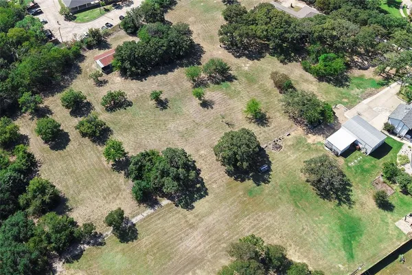 an aerial view of a house with a yard and lake view