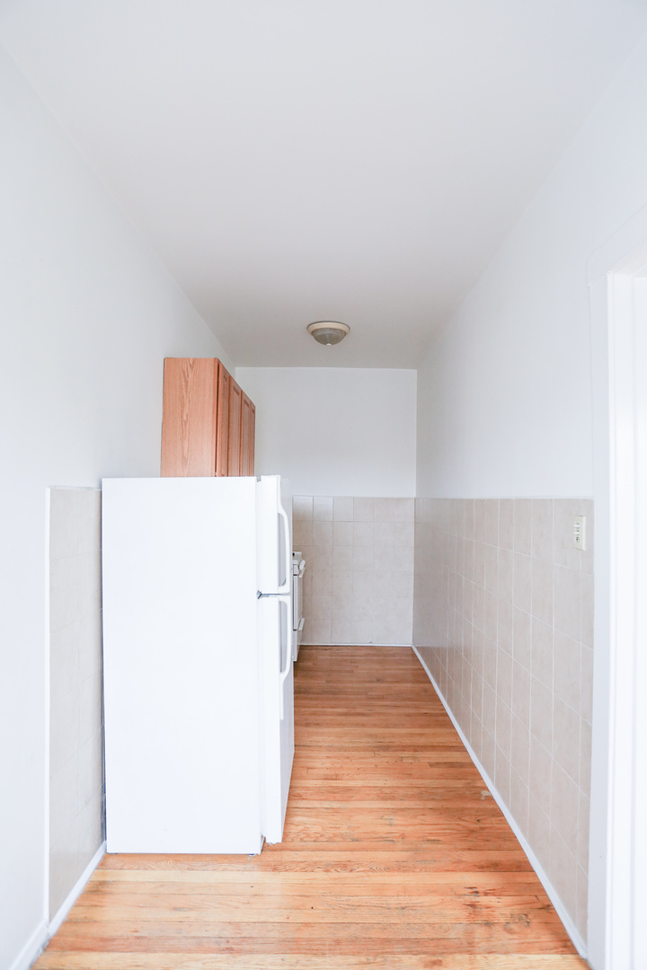 2712 North Milwaukee Avenue, Unit 309 Chicago, IL 60647 - Photo 6 of 9 a view of a refrigerator in kitchen and wooden floor