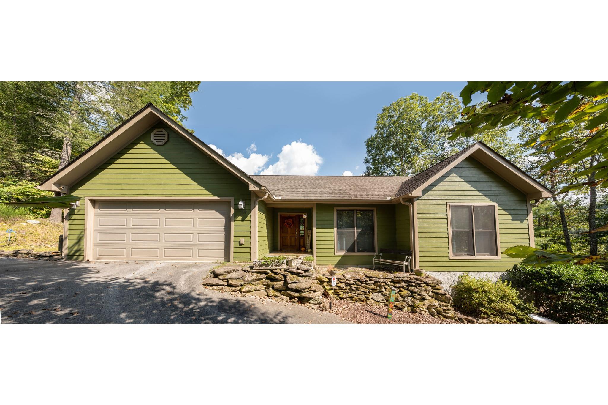 a front view of a house with a yard and potted plants
