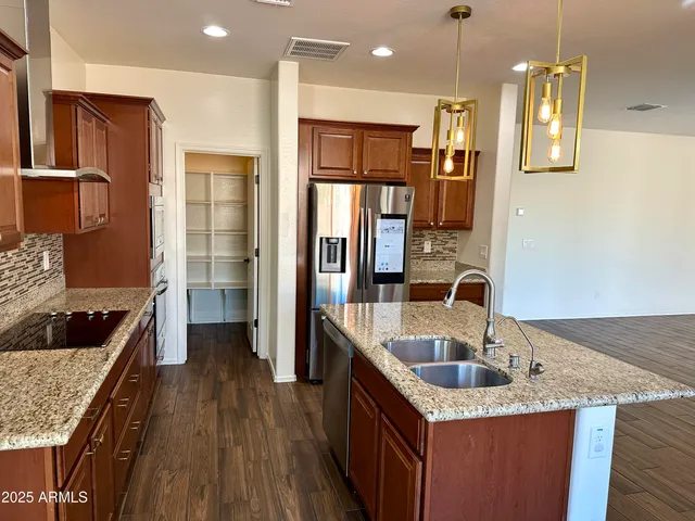 a kitchen that has a sink a refrigerator and wooden cabinets