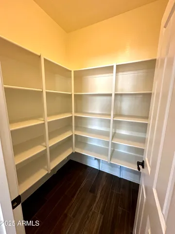 a view of walk in closet with empty racks