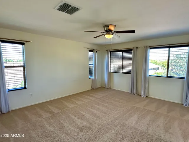 an empty room with windows and cabinet