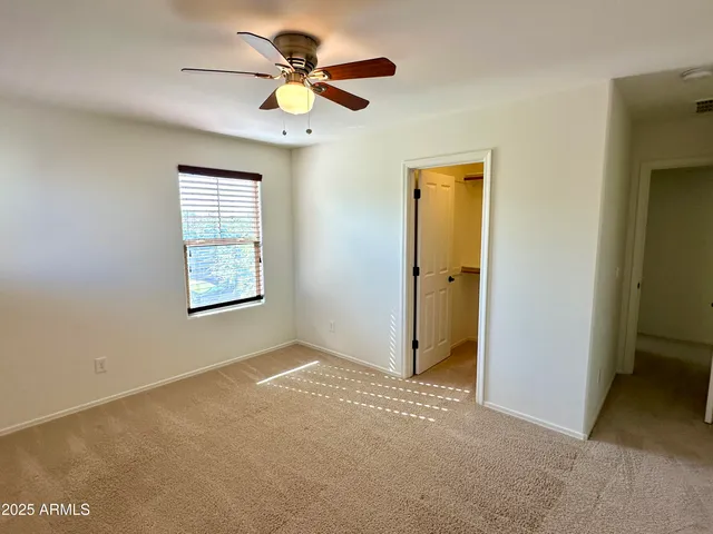 an empty room with a window and a fan