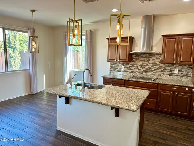 a kitchen with kitchen island granite countertop a sink stove and refrigerator