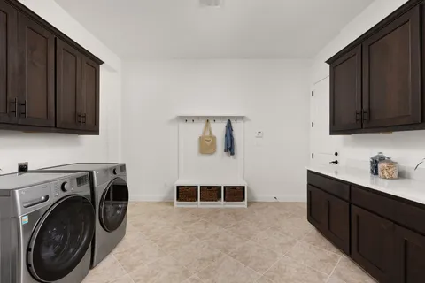 a utility room with sink dryer and washer