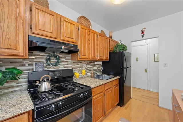 a kitchen with stainless steel appliances granite countertop a stove refrigerator and cabinets