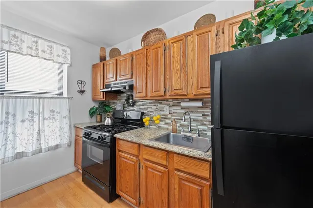 a kitchen with granite countertop a refrigerator stove and sink