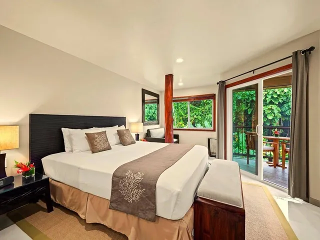 a bedroom with a bed and large windows