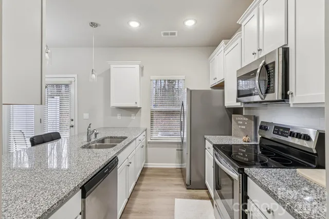 a kitchen with stainless steel appliances a stove a microwave and cabinets