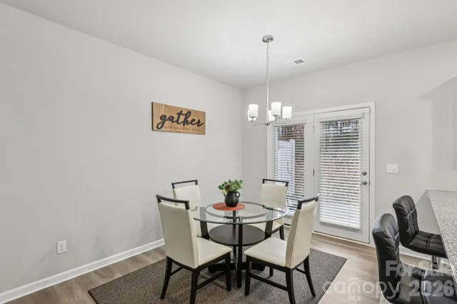 a view of a dining room with furniture a chandelier and wooden floor