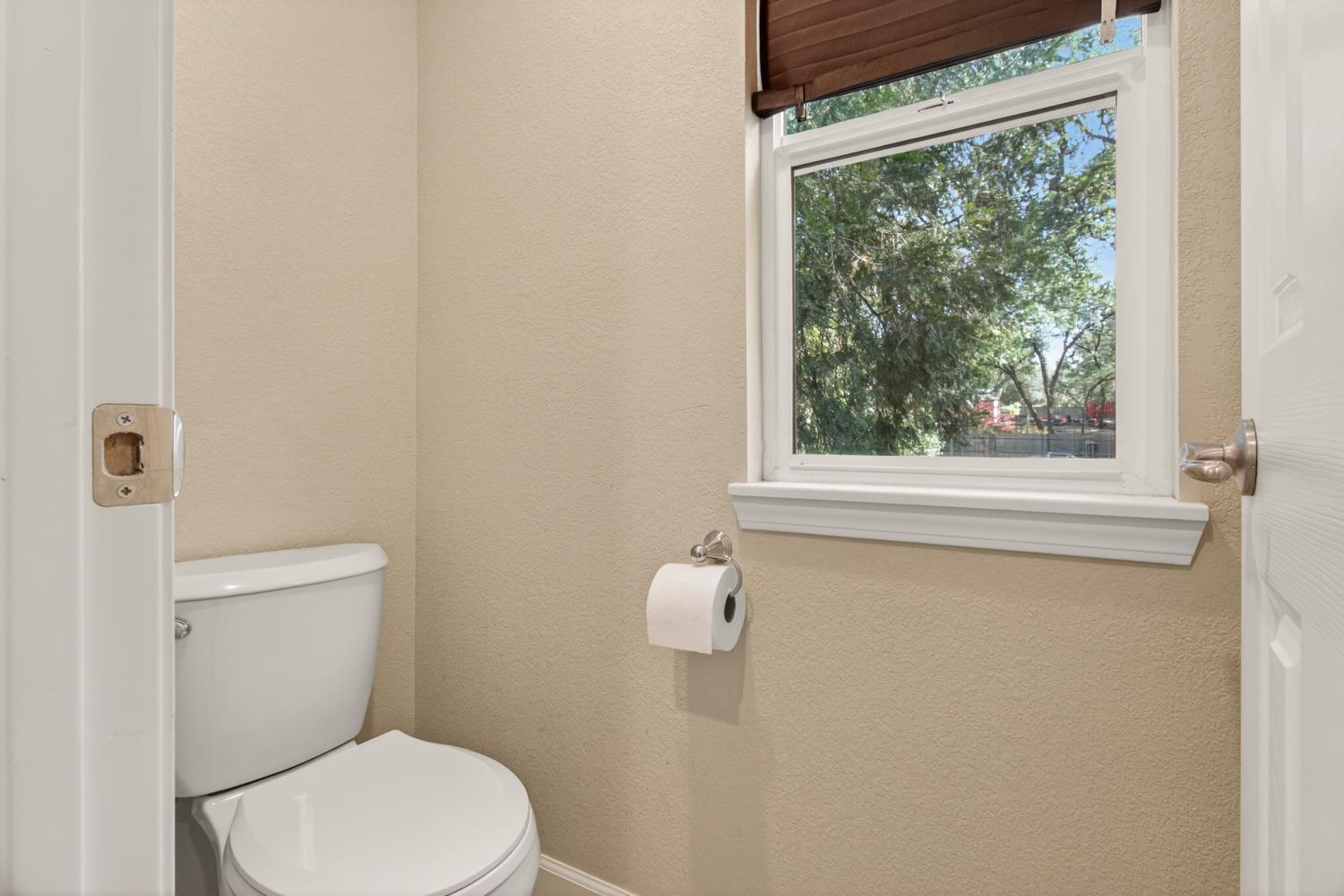 6332 Horseshoe Bar Road Loomis, CA 95650 - Photo 49 of 85 Powder room featuring a single window with a wood-finish blind, white window trim, and a wall-mounted toilet paper holder