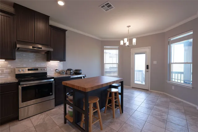 a kitchen with granite countertop a counter top space appliances and a ceiling fan