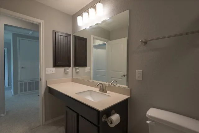 a bathroom with a sink toilet and mirror