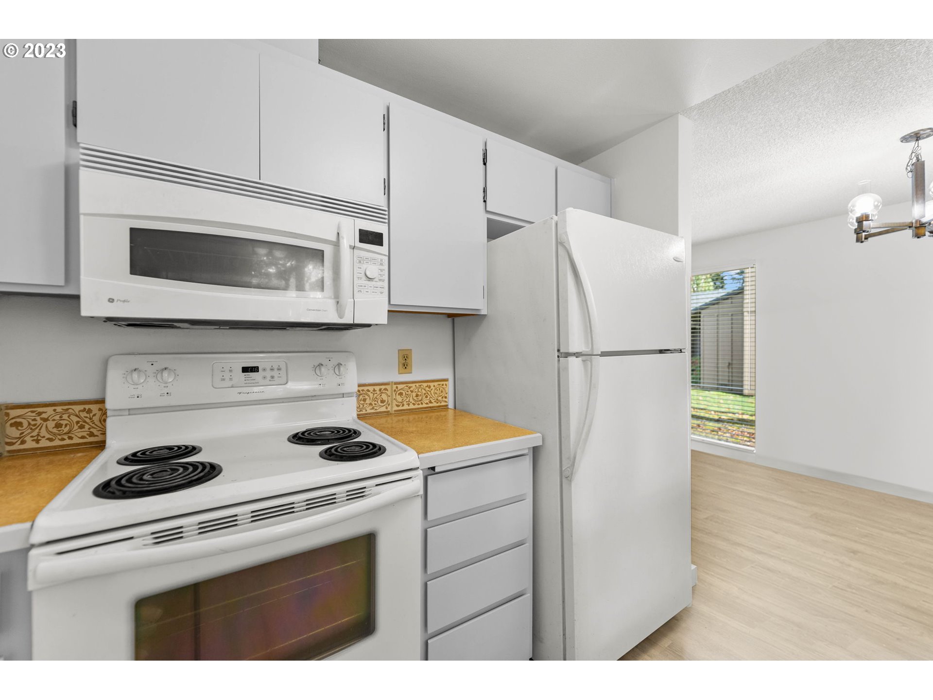 11856 Southeast Morrison Street Portland, OR 97216 - Photo 13 of 26 a kitchen with a stove microwave and refrigerator