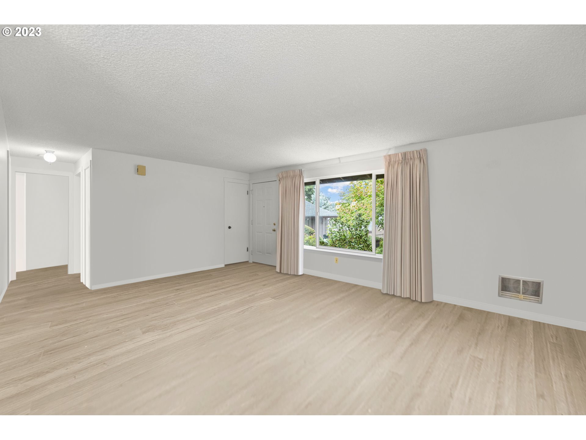 11856 Southeast Morrison Street Portland, OR 97216 - Photo 7 of 26 a view of an empty room with wooden floor and a window