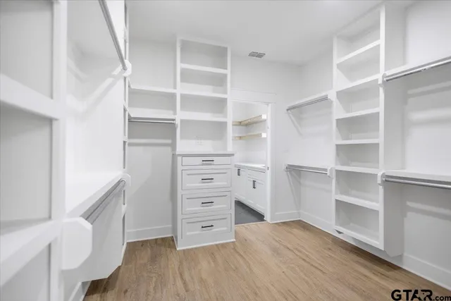 a view of walk in closet with empty racks