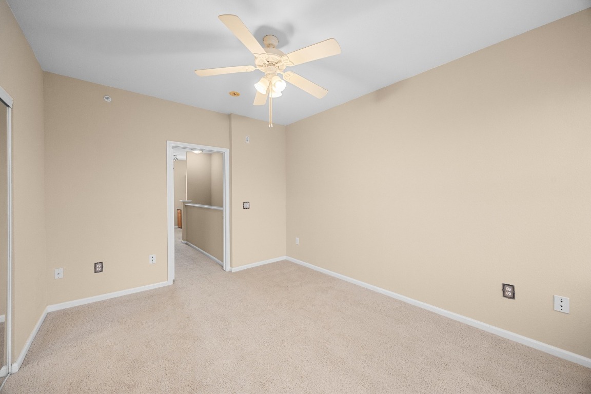 11203 Ranch Road 2222, Unit 1105 Austin, TX 78730 - Photo 18 of 35 an empty room with a ceiling fan and a window