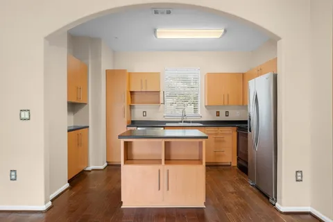 a kitchen with stainless steel appliances granite countertop a stove a sink and a refrigerator