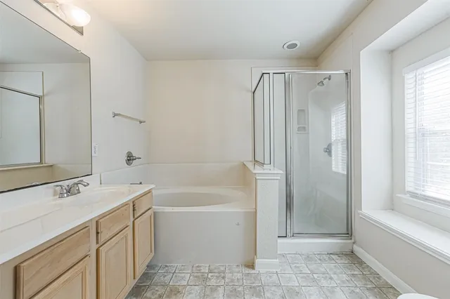 a bathroom with a tub a sink and a mirror