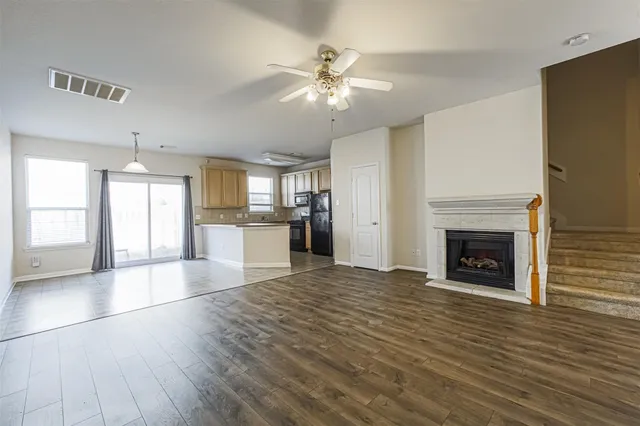 a view of an empty room with a fireplace and a window