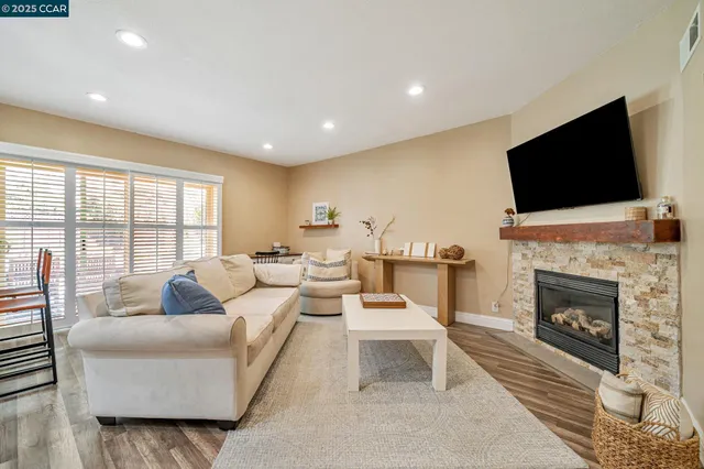 a living room with furniture a fireplace and a flat screen tv
