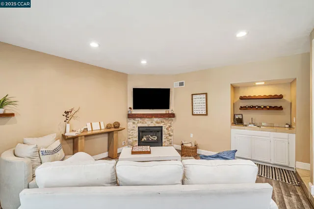 a living room with furniture a flat screen tv and a fireplace