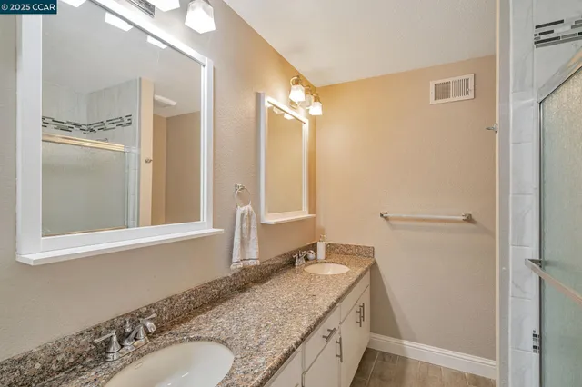 a bathroom with a granite countertop sink and a mirror