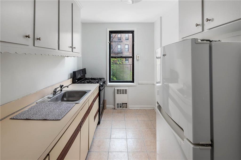 2425 Haring Street, Unit 2K Brooklyn, NY 11235 - Photo 6 of 12 a kitchen with a sink stove and refrigerator