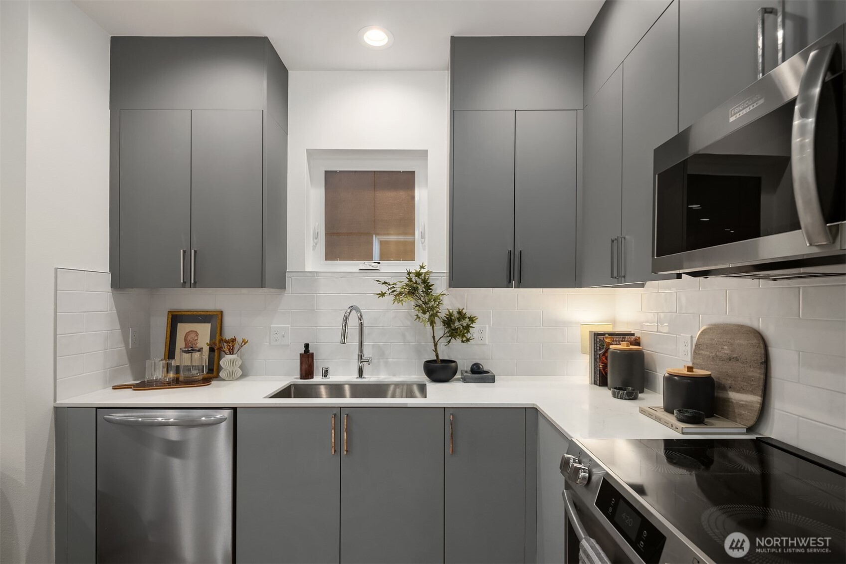1827 14th Avenue, Unit B Seattle, WA 98122 - Photo 6 of 27 a kitchen with stainless steel appliances a sink a microwave and cabinets
