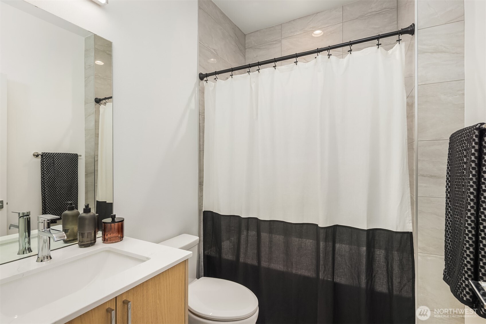 1827 14th Avenue, Unit B Seattle, WA 98122 - Photo 10 of 27 a bathroom with a sink a toilet a mirror and shower curtain