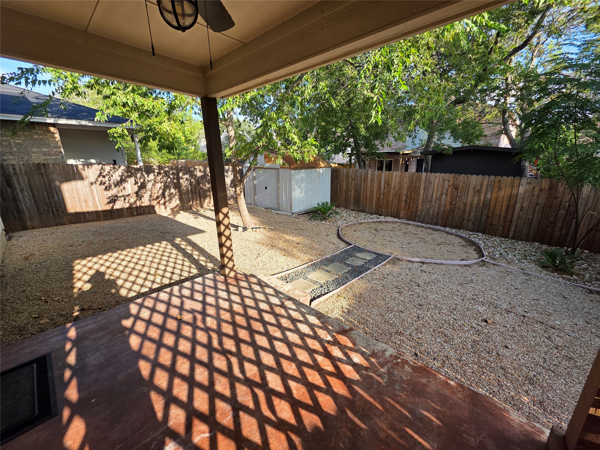 2210 Wilma Rudolph Road Austin, TX 78748 - Photo 19 of 20 Mature trees shade a low-maintenance gravel backyard complete with a storage shed and covered patio.