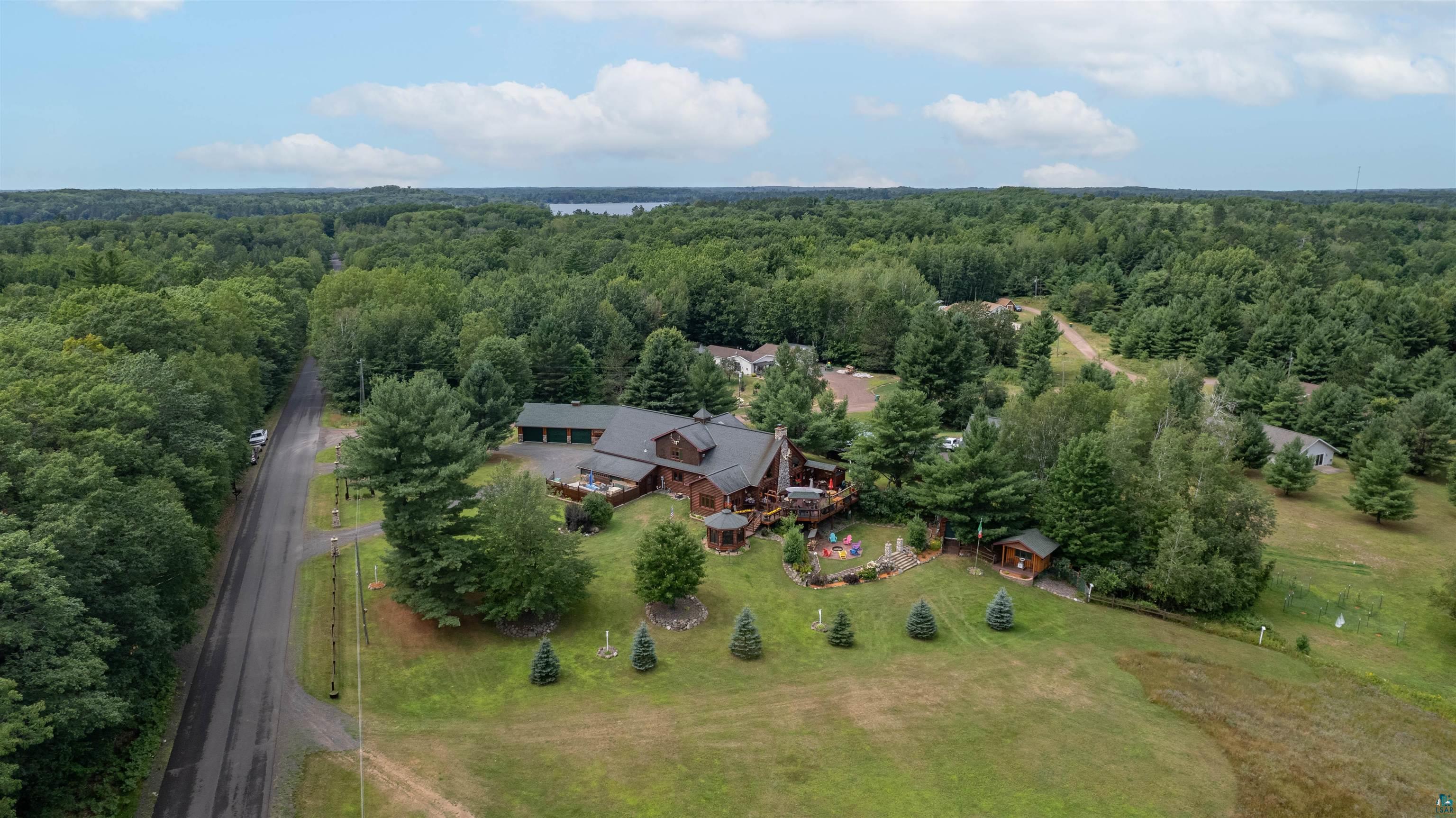 11911 East Rowe Road Lake Nebagamon, WI 54849 - Photo 6 of 61 Expansive property featuring a rustic-style residence, extensive surrounding woodlands, and a visible distant lake