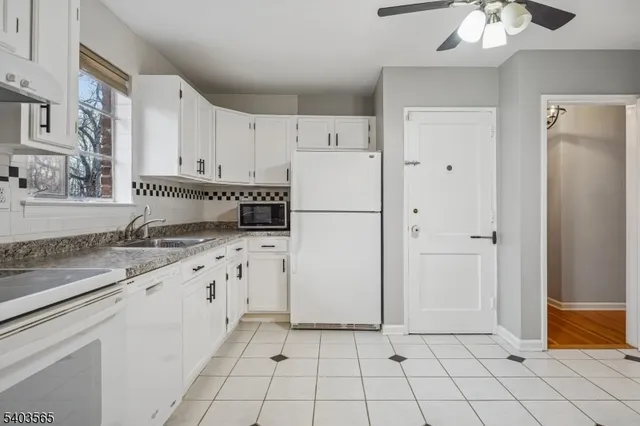 a kitchen with white cabinets and white appliances