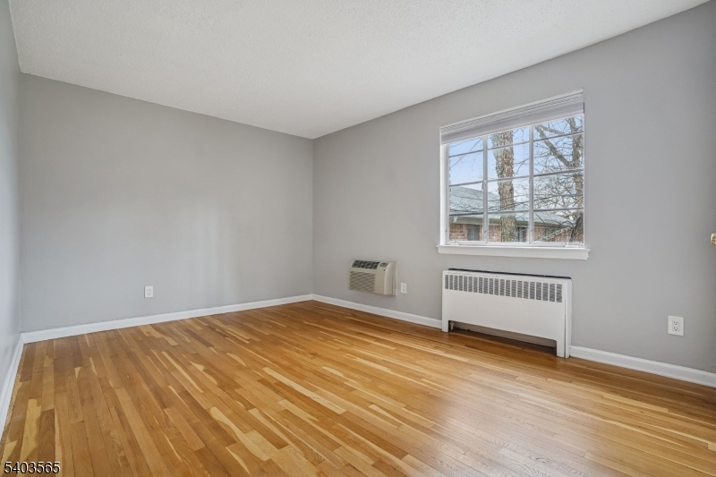 23 Troy Drive, Unit B Springfield, NJ 07081 - Photo 18 of 22 a view of an empty room with wooden floor and a window