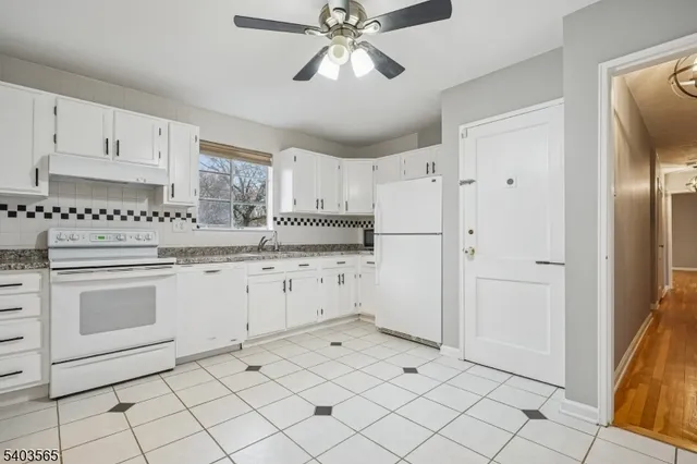 a kitchen with white cabinets and white appliances