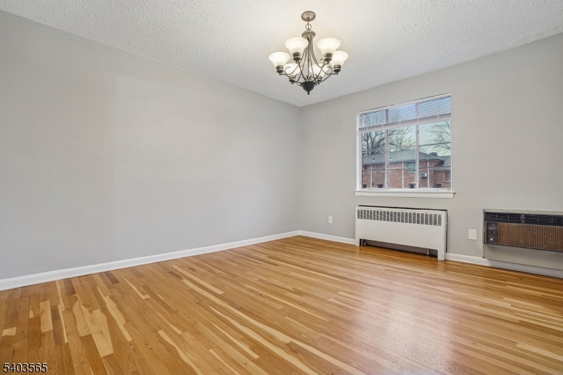 23 Troy Drive, Unit B Springfield, NJ 07081 - Photo 10 of 22 a view of an empty room with a window and wooden floor
