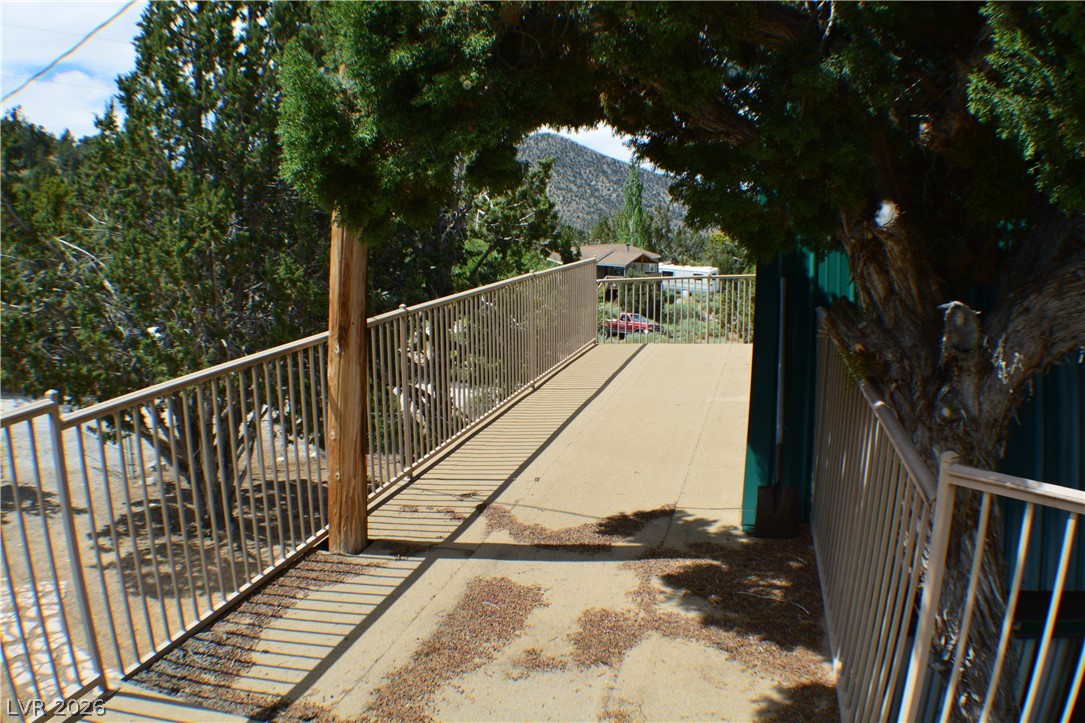 1321 Trout Canyon Road Las Vegas, NV 89124 - Photo 35 of 50 A ramped walkway with sturdy railings offers accessible passage through the lush, wooded property.