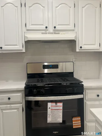 a kitchen with white cabinets and black appliances