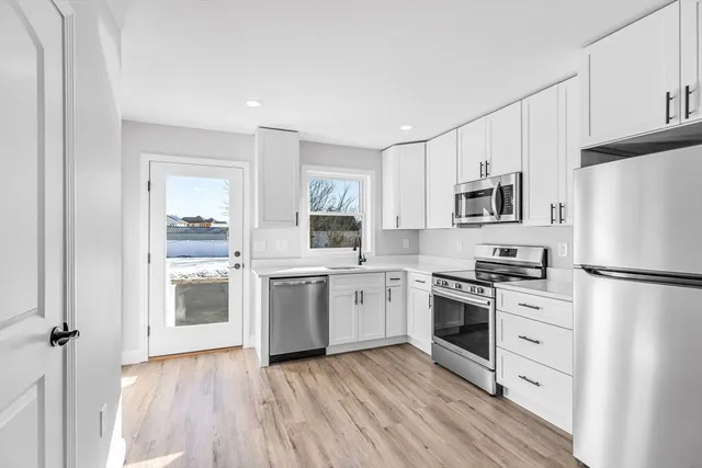 a kitchen with white cabinets stainless steel appliances and sink